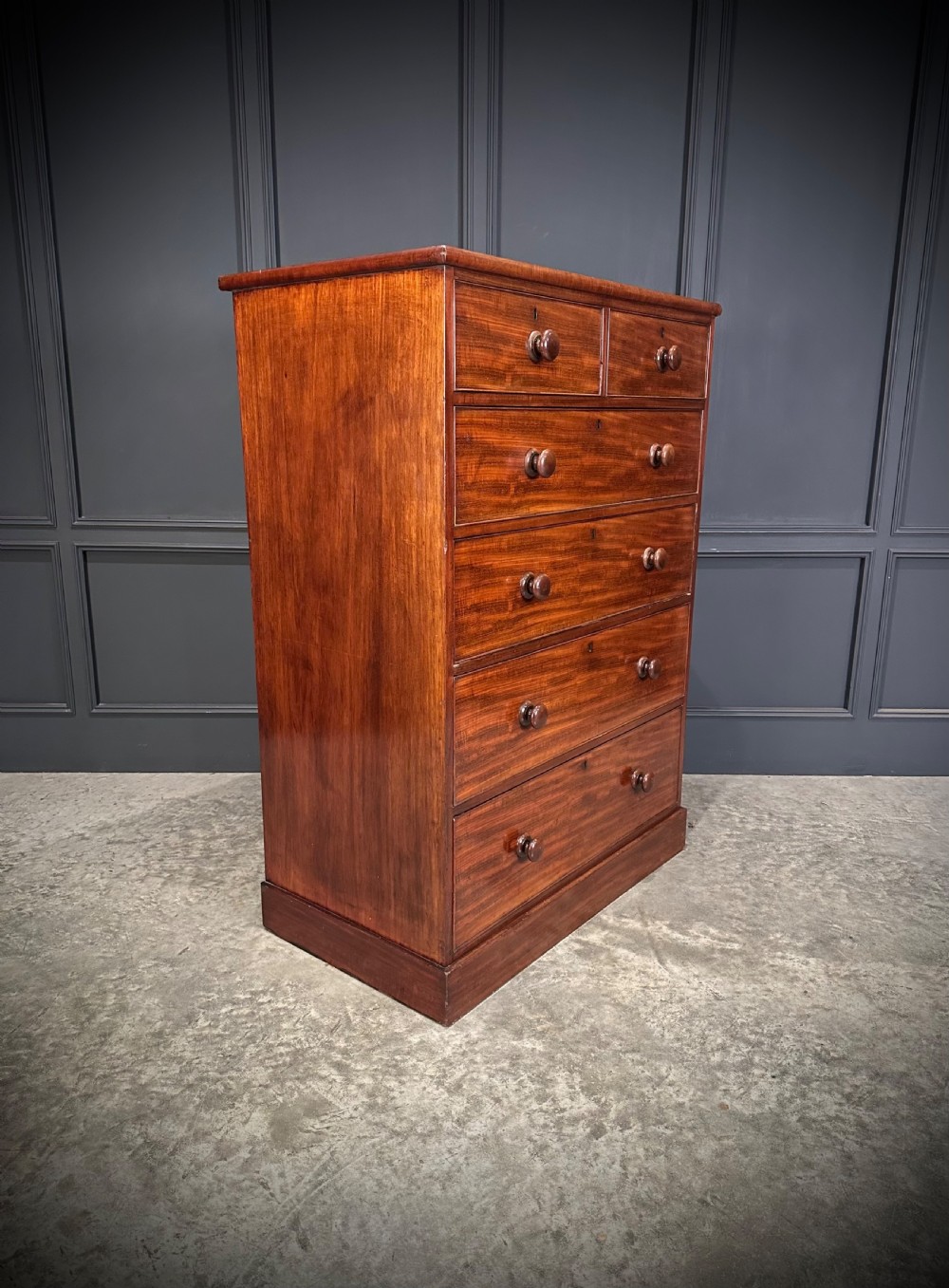 A nineteenth-century Victorian mahogany chest of drawers featuring two short drawers over four long drawers with turned wooden handles on a plinth base. View II