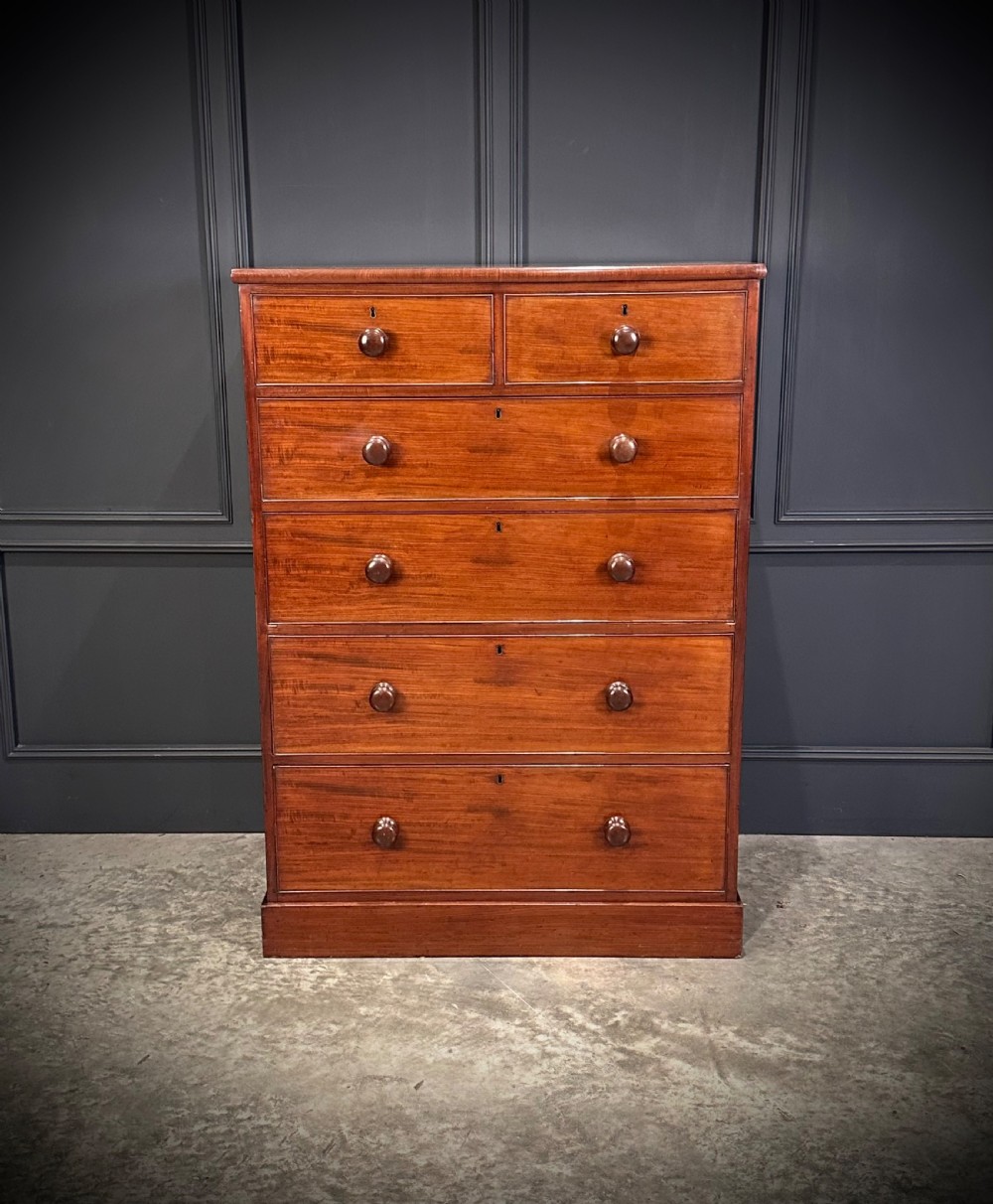 A nineteenth-century Victorian mahogany chest of drawers featuring two short drawers over four long drawers with turned wooden handles on a plinth base. View III