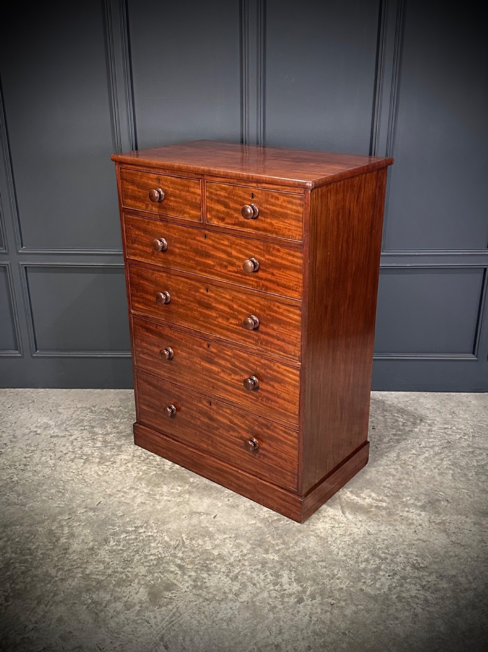 A nineteenth-century Victorian mahogany chest of drawers featuring two short drawers over four long drawers with turned wooden handles on a plinth base. View IV