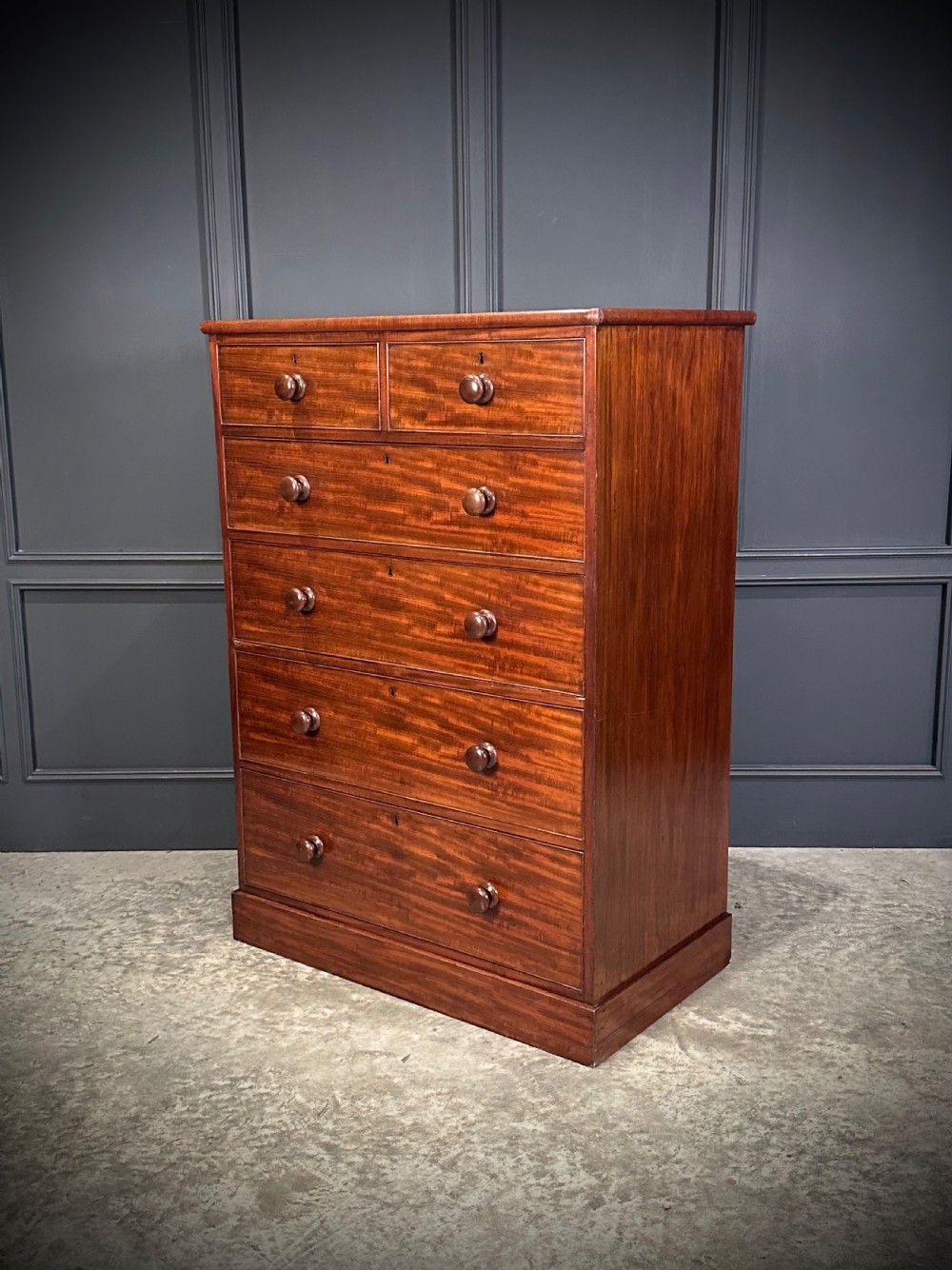 A nineteenth-century Victorian mahogany chest of drawers featuring two short drawers over four long drawers with turned wooden handles on a plinth base.