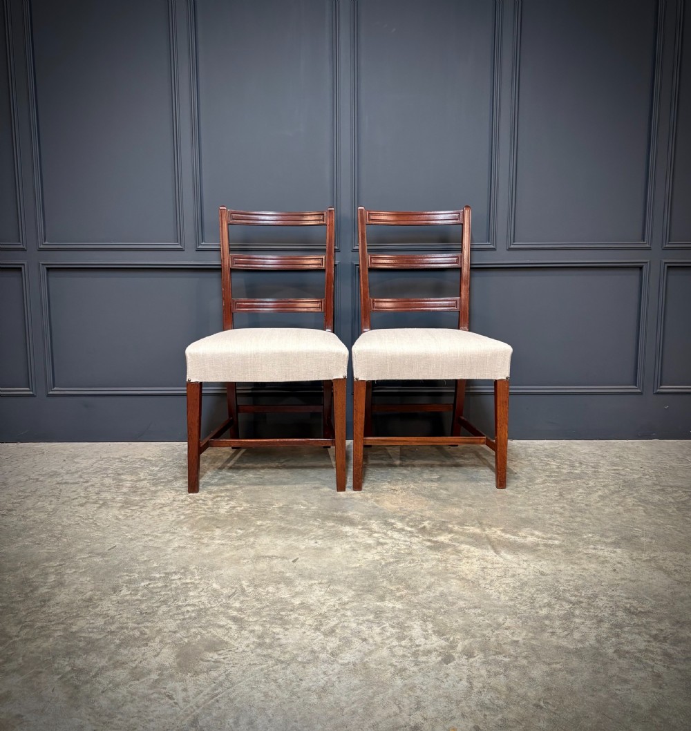 A set of eighteen Georgian mahogany dining chairs featuring triple horizontal bar backrests and light cream upholstered seats. View III