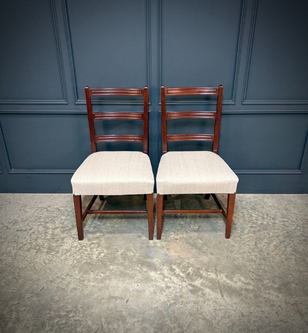 A set of eighteen Georgian mahogany dining chairs featuring triple horizontal bar backrests and light cream upholstered seats. View IV