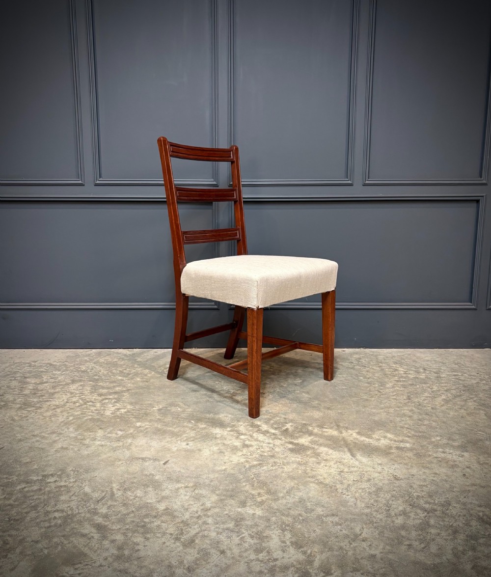 A set of eighteen Georgian mahogany dining chairs featuring triple horizontal bar backrests and light cream upholstered seats. View V