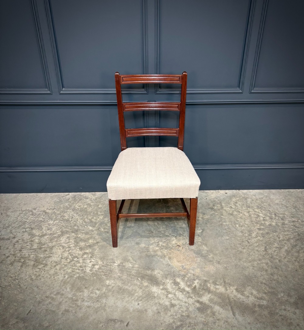 A set of eighteen Georgian mahogany dining chairs featuring triple horizontal bar backrests and light cream upholstered seats. View VII