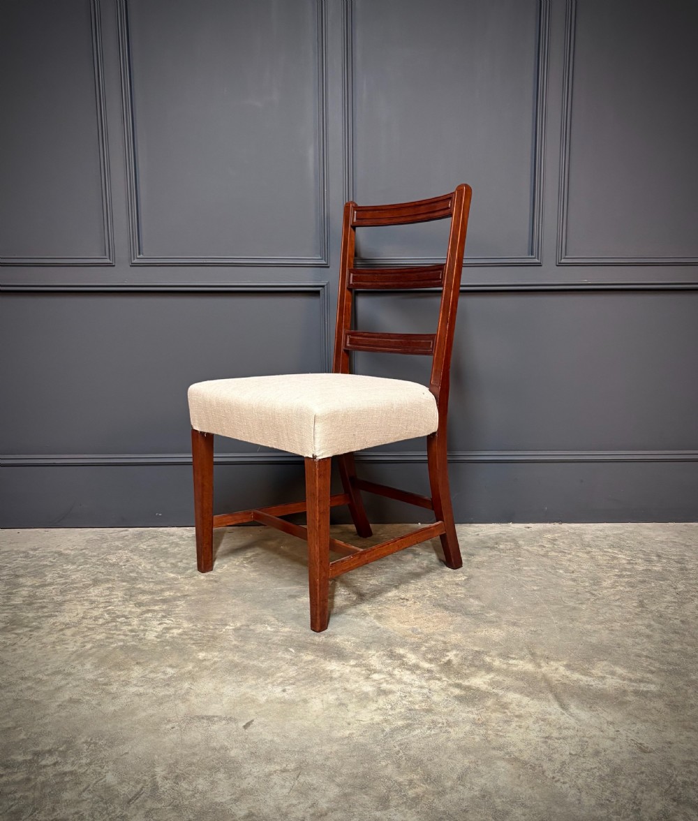 A set of eighteen Georgian mahogany dining chairs featuring triple horizontal bar backrests and light cream upholstered seats. View VIII