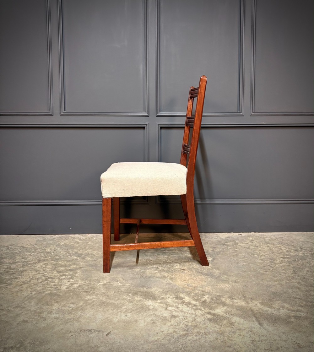 A set of eighteen Georgian mahogany dining chairs featuring triple horizontal bar backrests and light cream upholstered seats. View IX