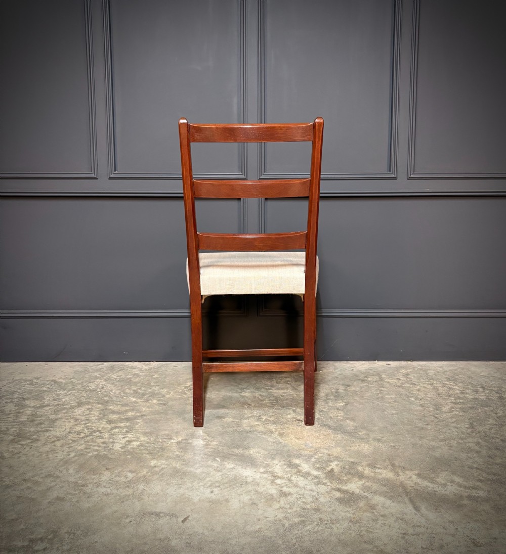 A set of eighteen Georgian mahogany dining chairs featuring triple horizontal bar backrests and light cream upholstered seats. View X