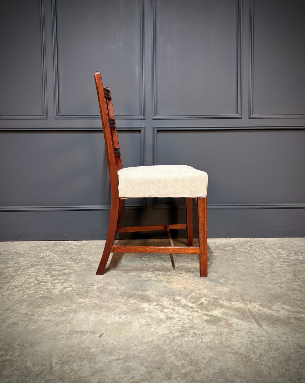 A set of eighteen Georgian mahogany dining chairs featuring triple horizontal bar backrests and light cream upholstered seats. View XI