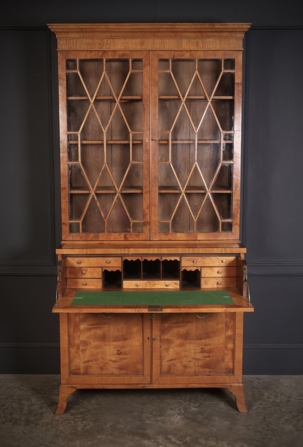 A Georgian satinwood secretaire bookcase with diamond astragal glazed doors above a lower cupboard base. View IV