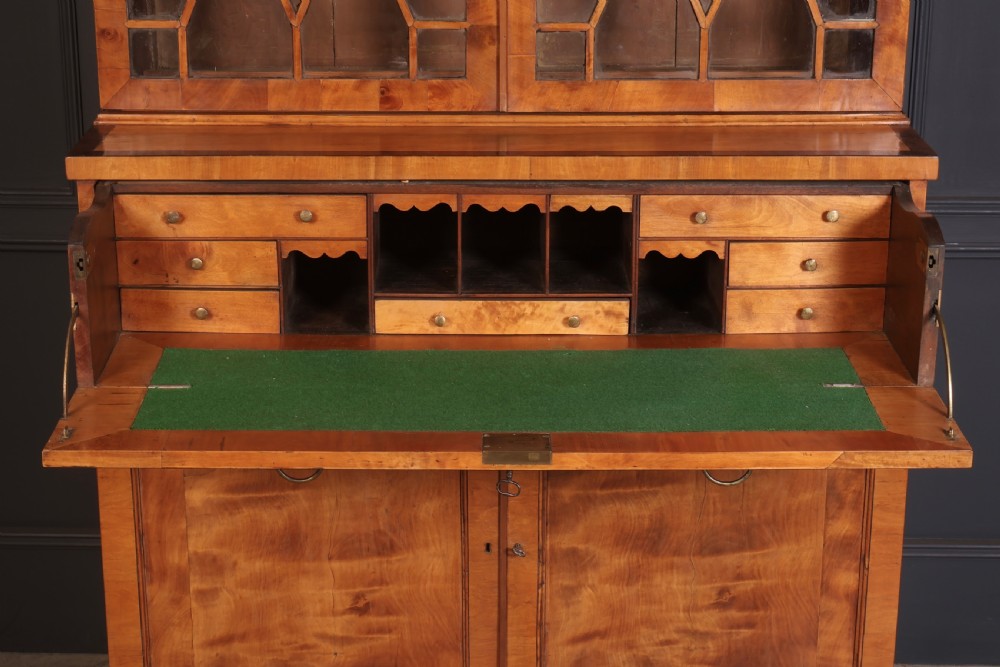 A Georgian satinwood secretaire bookcase with diamond astragal glazed doors above a lower cupboard base. View V