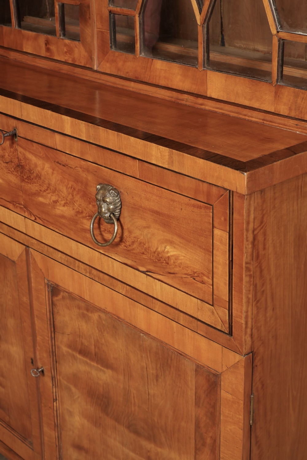 A Georgian satinwood secretaire bookcase with diamond astragal glazed doors above a lower cupboard base. View VII