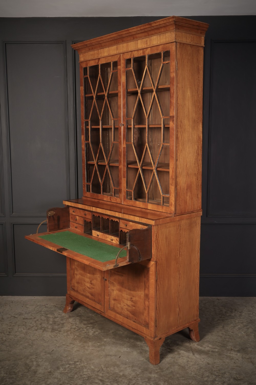 A Georgian satinwood secretaire bookcase with diamond astragal glazed doors above a lower cupboard base. View IX