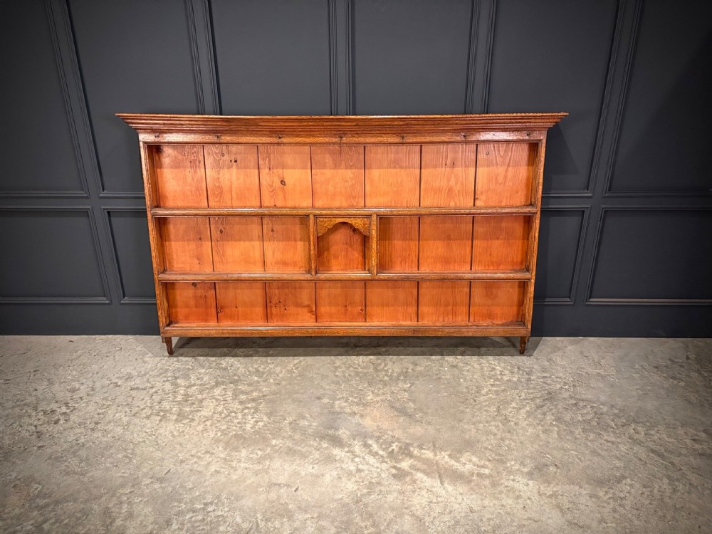 An eighteenth-century oak welsh dresser featuring a three-shelf open upper rack and a lower base with three drawers and two panelled cupboard doors. View IV