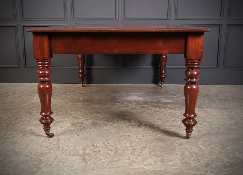 A Victorian mahogany partners writing table with a rich red leather inlaid top, frieze drawers, and turned legs set on brass castors. View XVIII