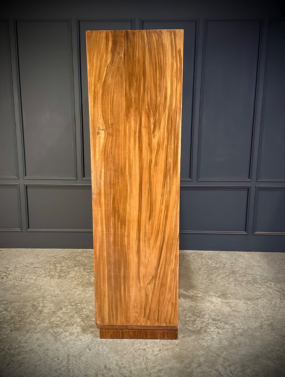 A tall three-door Art Deco wardrobe crafted from figured burr walnut with a stepped top cornice and plinth base. View VI