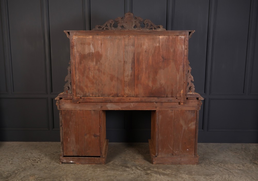 A large bleached oak pedestal sideboard featuring elaborate fruit swags, carved mask details, twin lower cupboards, and an integrated rectangular mirror superstructure. View VIII