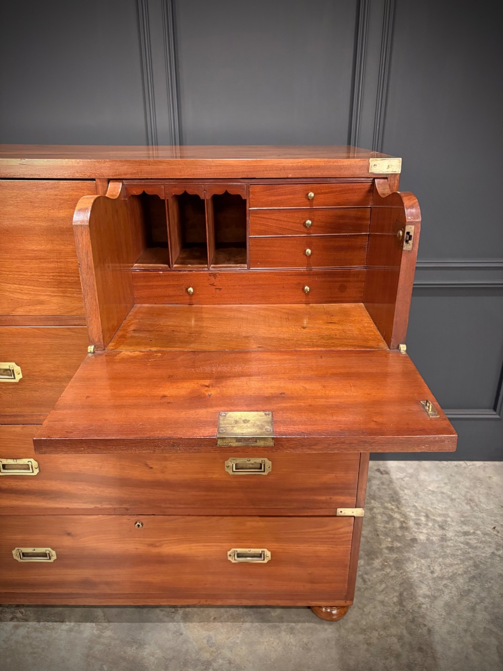A Victorian mahogany military campaign chest featuring two stackable sections, brass corner brackets, flush recessed handles, and turned bun feet. View IV