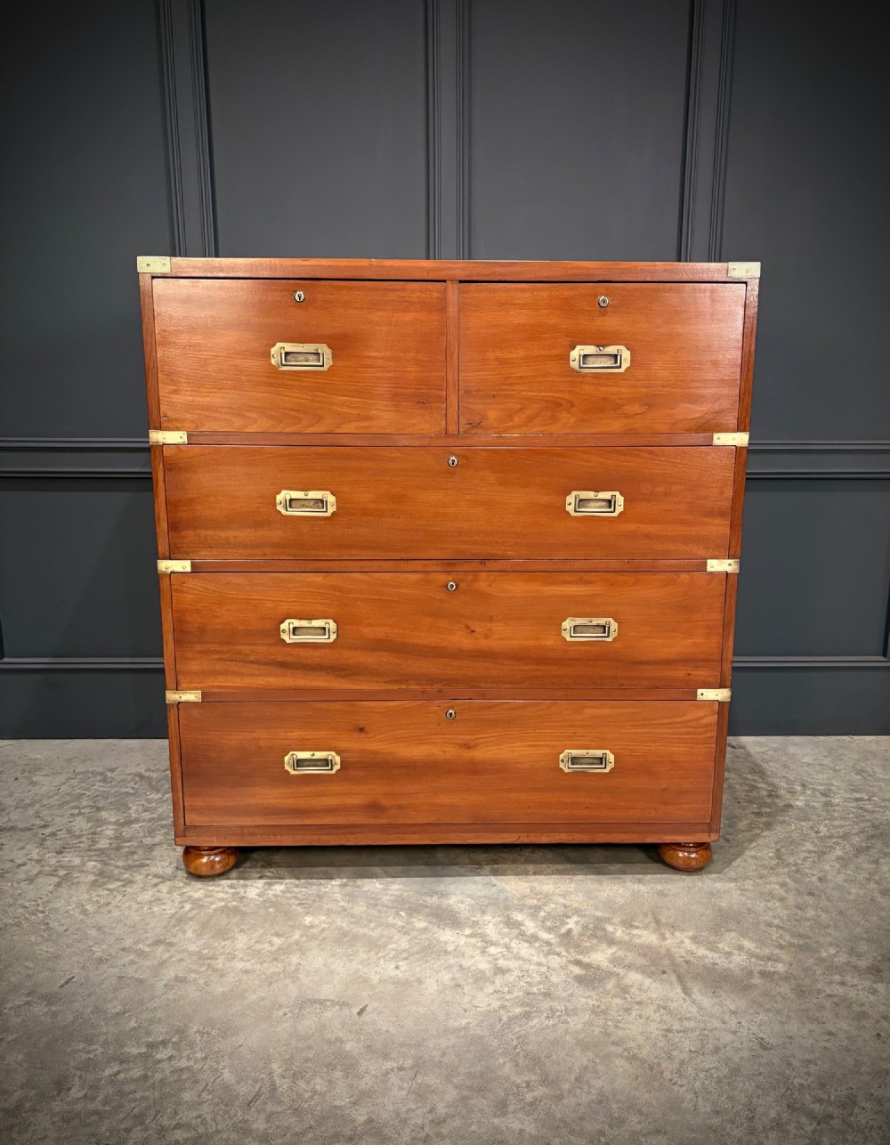 A Victorian mahogany military campaign chest featuring two stackable sections, brass corner brackets, flush recessed handles, and turned bun feet. View V