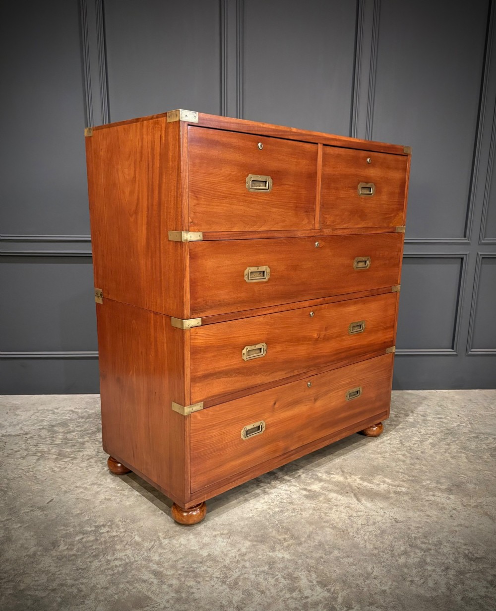 A Victorian mahogany military campaign chest featuring two stackable sections, brass corner brackets, flush recessed handles, and turned bun feet. View VI