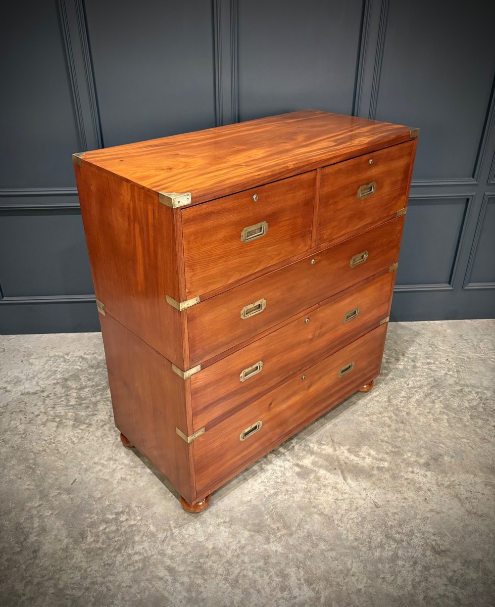 A Victorian mahogany military campaign chest featuring two stackable sections, brass corner brackets, flush recessed handles, and turned bun feet. View VII