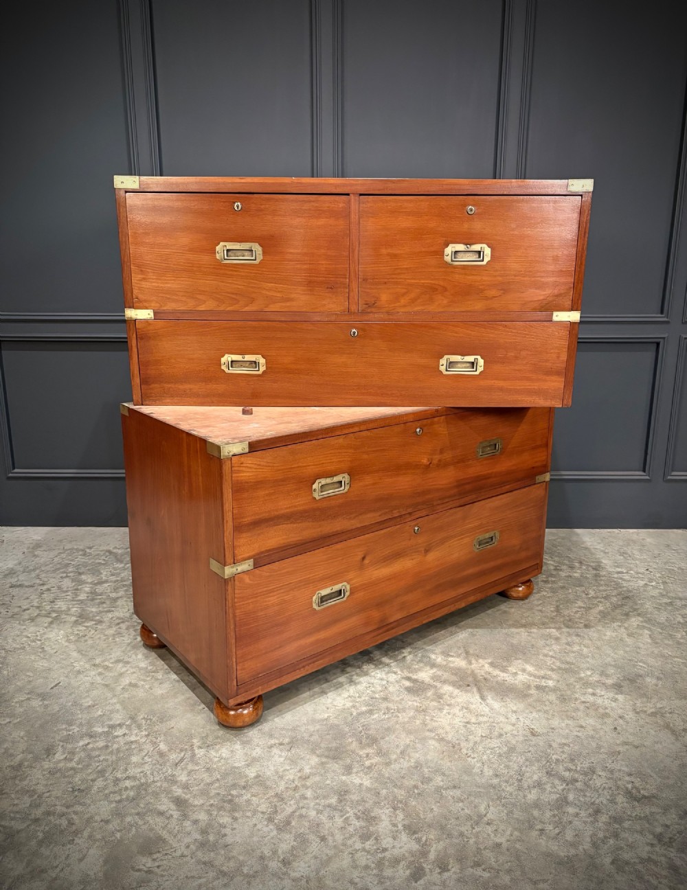 A Victorian mahogany military campaign chest featuring two stackable sections, brass corner brackets, flush recessed handles, and turned bun feet. View VIII