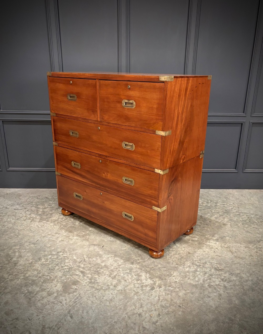 A Victorian mahogany military campaign chest featuring two stackable sections, brass corner brackets, flush recessed handles, and turned bun feet. View IX