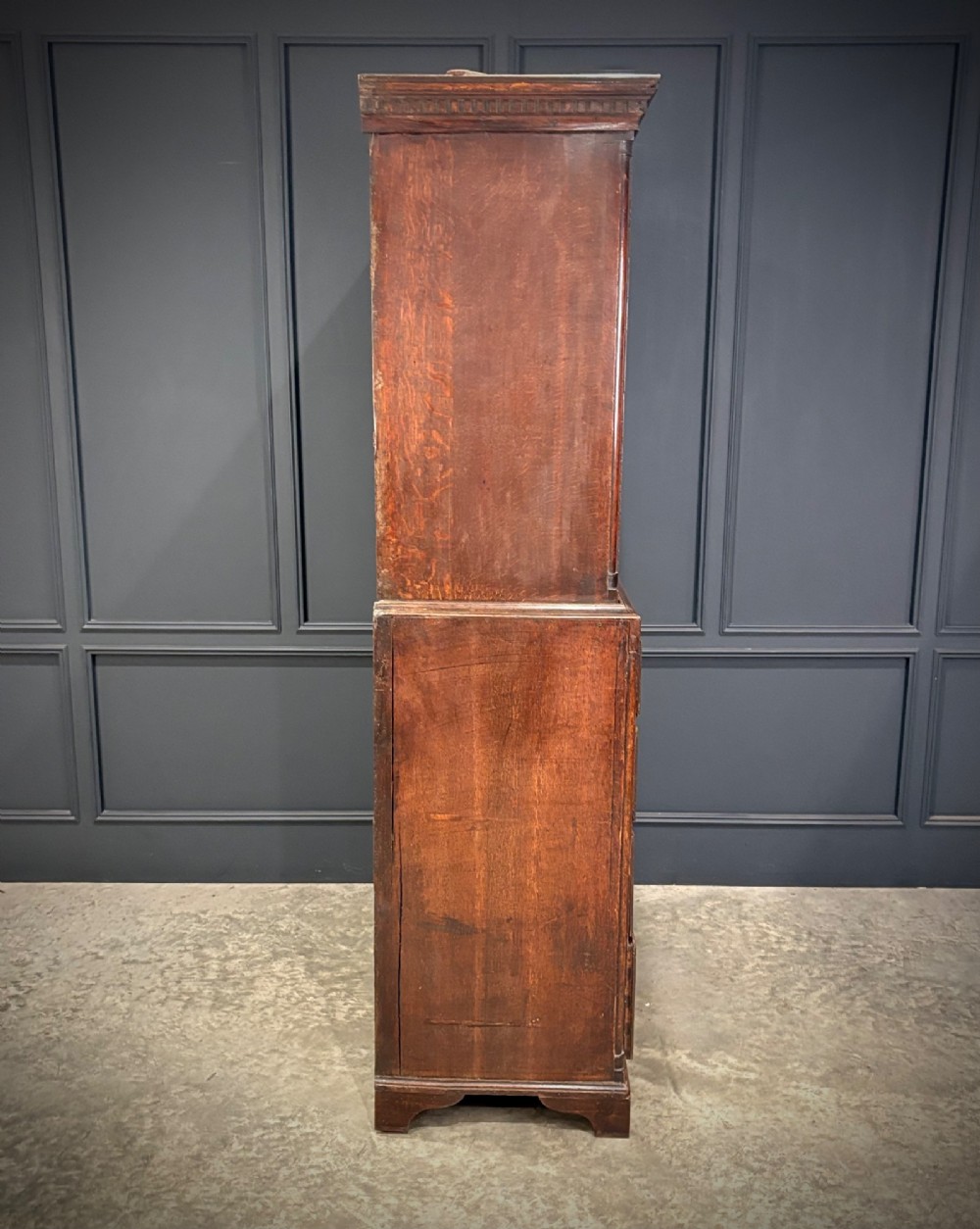 An 18th-century carved dark oak housekeepers cupboard featuring upper panel doors with geometric lozenge carving above a base with five carved drawers. View XI