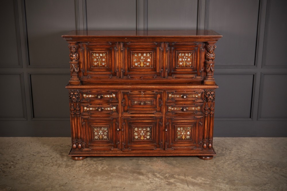 A two-tiered dark walnut sideboard featuring geometric mother of pearl inlays, hand-carved figurative relief accents, drawers, and panelled cabinet doors. View II