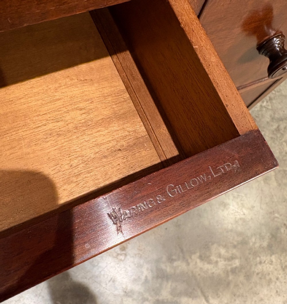 A tall antique mahogany chest of drawers featuring an upper arrangement of small drawers over three graduated full-width drawers, resting on bracket feet. View V