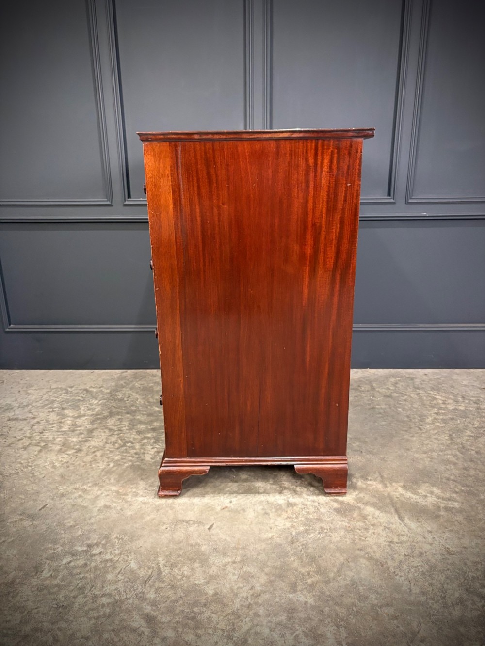 A tall antique mahogany chest of drawers featuring an upper arrangement of small drawers over three graduated full-width drawers, resting on bracket feet. View XII