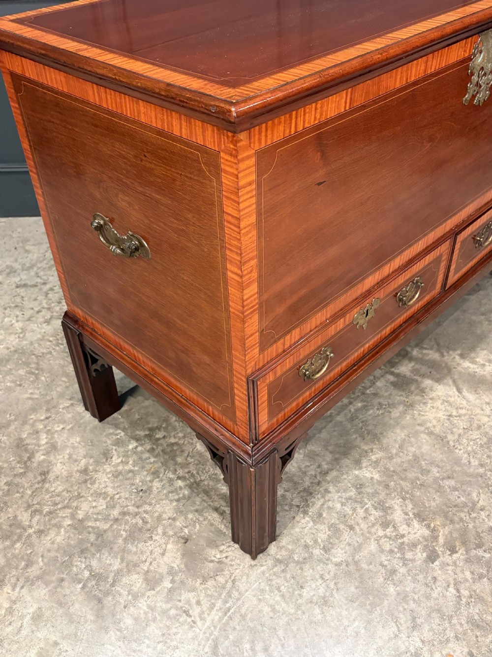 A Georgian inlaid mahogany silver chest on stand featuring satinwood crossbanding, brass side carrying handles, two lower drawers, and square legs with bracket corner supports. View III