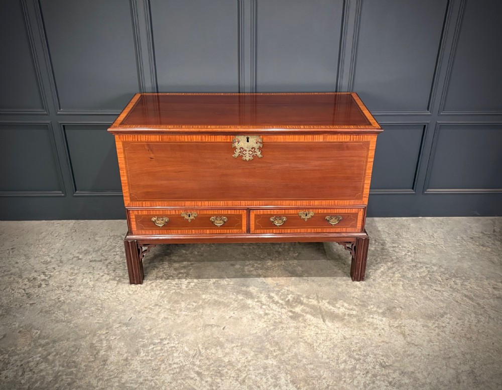 A Georgian inlaid mahogany silver chest on stand featuring satinwood crossbanding, brass side carrying handles, two lower drawers, and square legs with bracket corner supports. View V