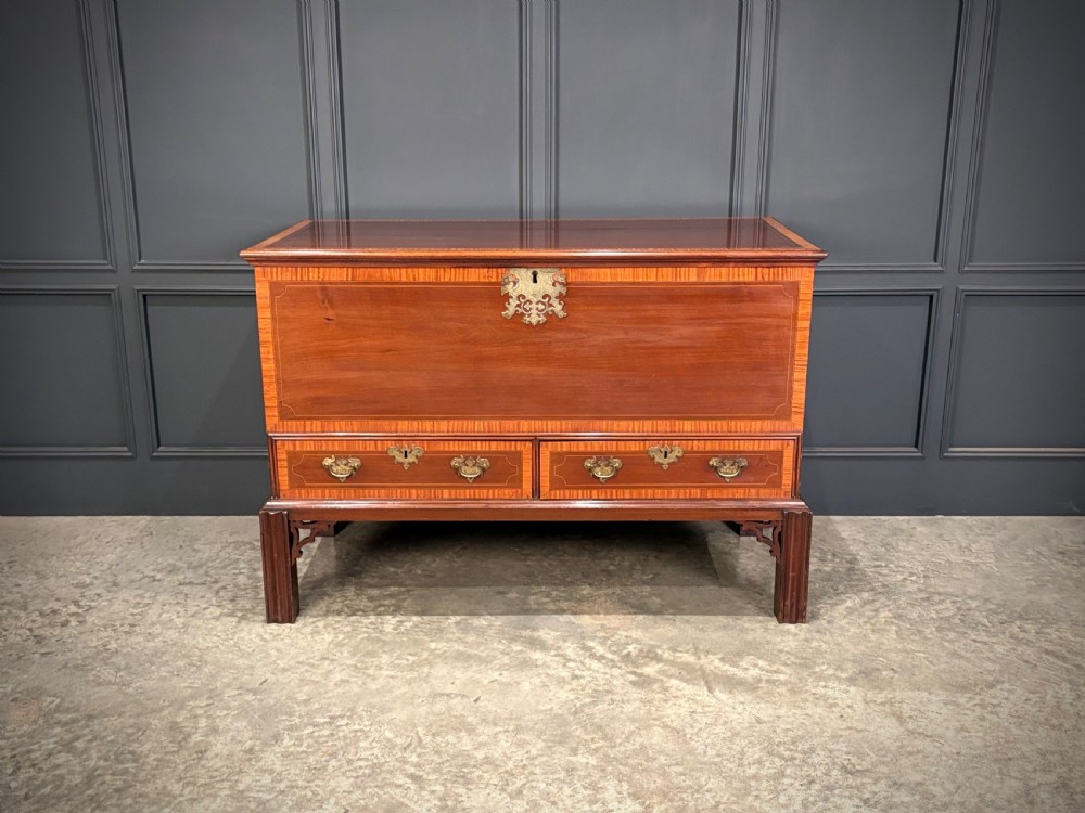 A Georgian inlaid mahogany silver chest on stand featuring satinwood crossbanding, brass side carrying handles, two lower drawers, and square legs with bracket corner supports. View VI