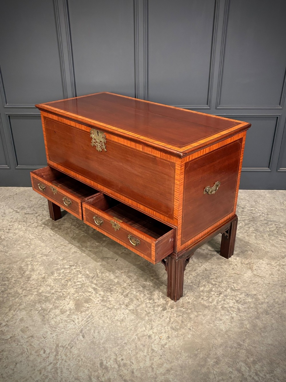 A Georgian inlaid mahogany silver chest on stand featuring satinwood crossbanding, brass side carrying handles, two lower drawers, and square legs with bracket corner supports. View IX
