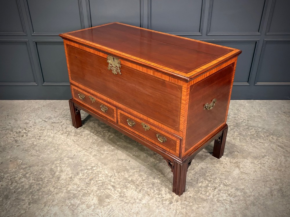 A Georgian inlaid mahogany silver chest on stand featuring satinwood crossbanding, brass side carrying handles, two lower drawers, and square legs with bracket corner supports. View X