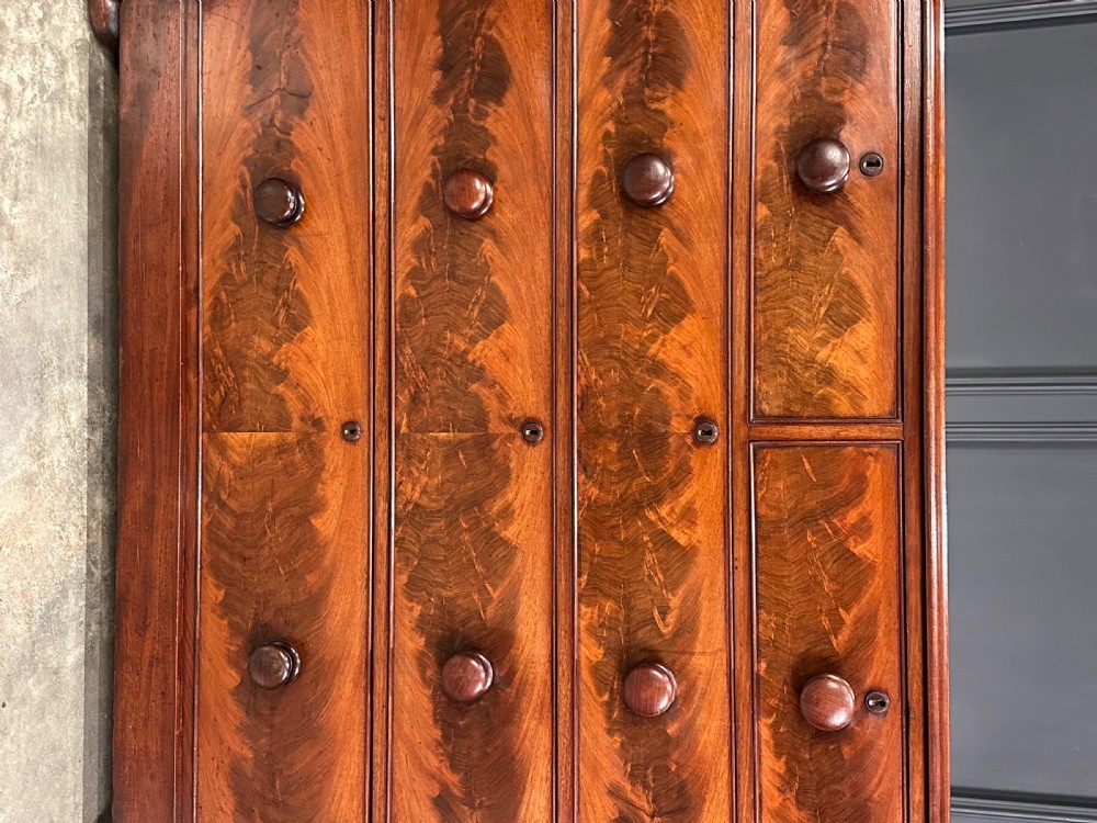 A Victorian mahogany chest of drawers featuring a two short over three long drawer arrangement with turned wood handles and flame mahogany grain patterns. View VII