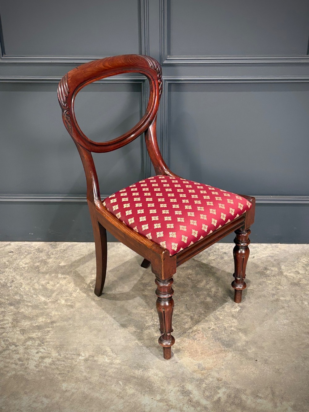 A pair of Victorian mahogany side chairs with rounded balloon backs, turned front legs, and red patterned fabric seats. View V