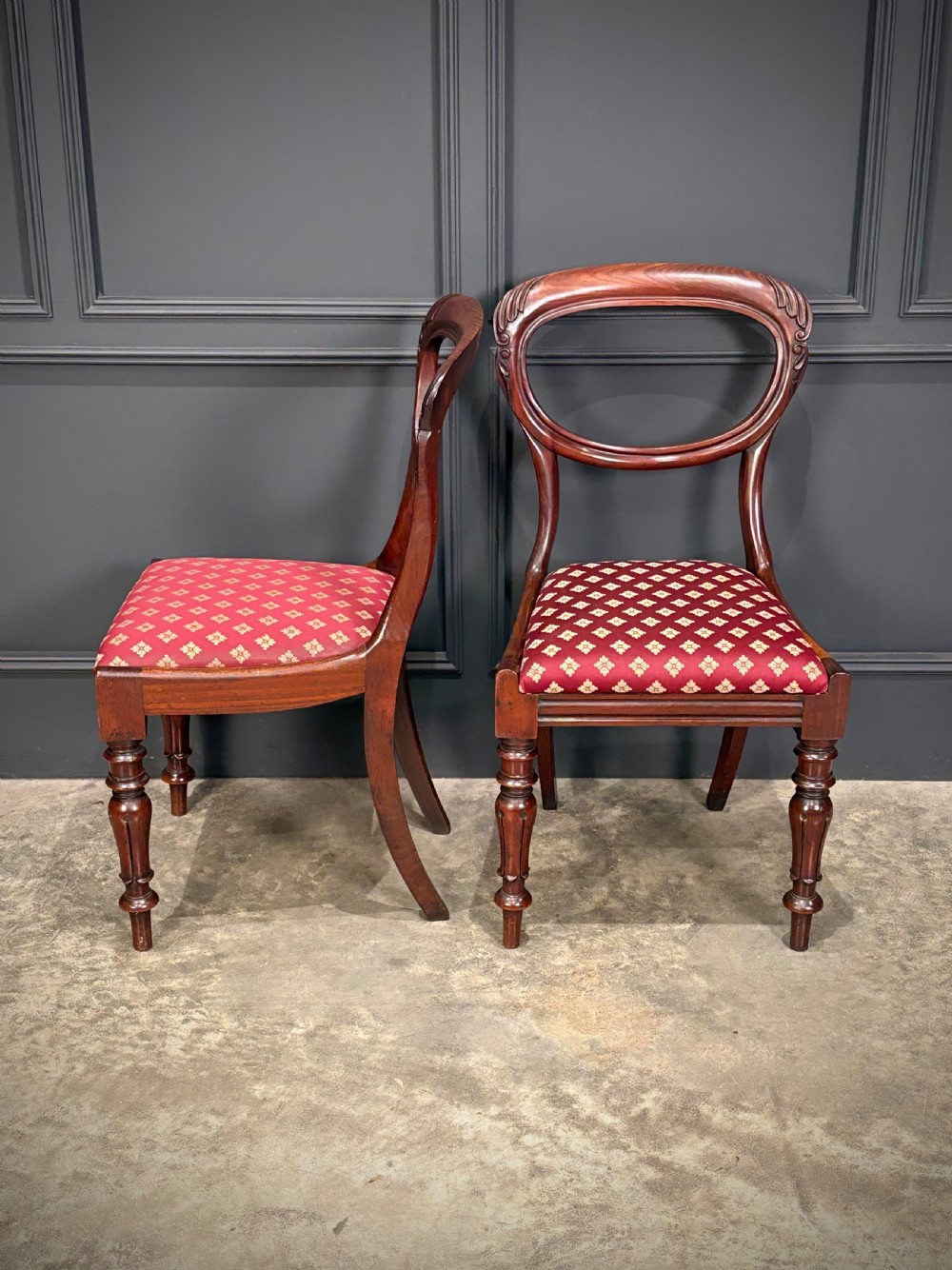 A pair of Victorian mahogany side chairs with rounded balloon backs, turned front legs, and red patterned fabric seats. View VI