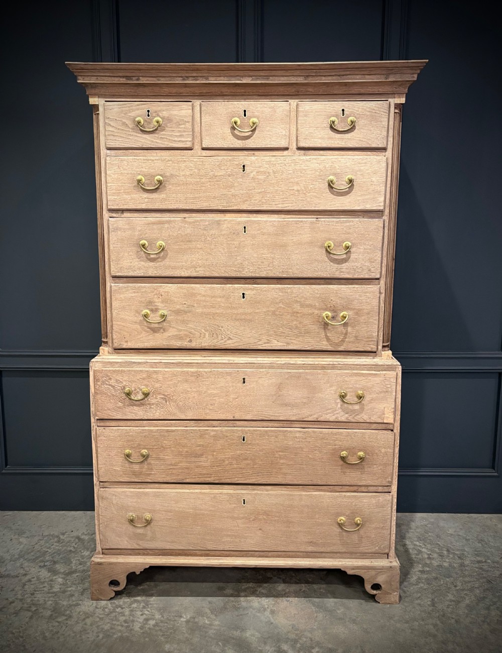 A Georgian bleached oak chest on chest featuring a two-part stacked design with brass drop handles and bracket feet. View II