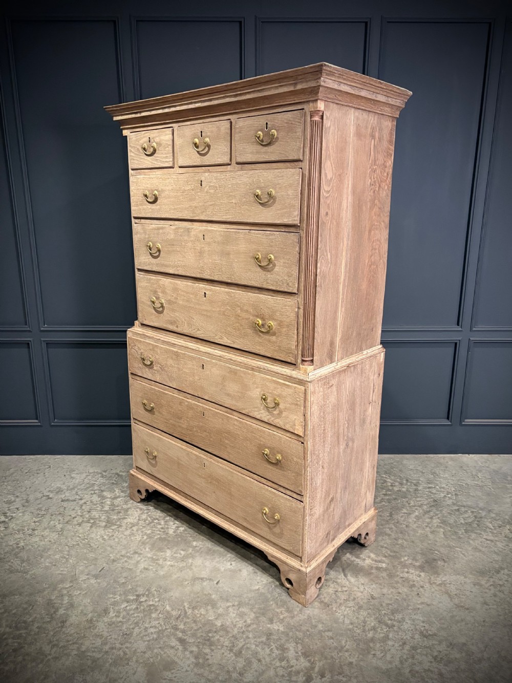 A Georgian bleached oak chest on chest featuring a two-part stacked design with brass drop handles and bracket feet. View III