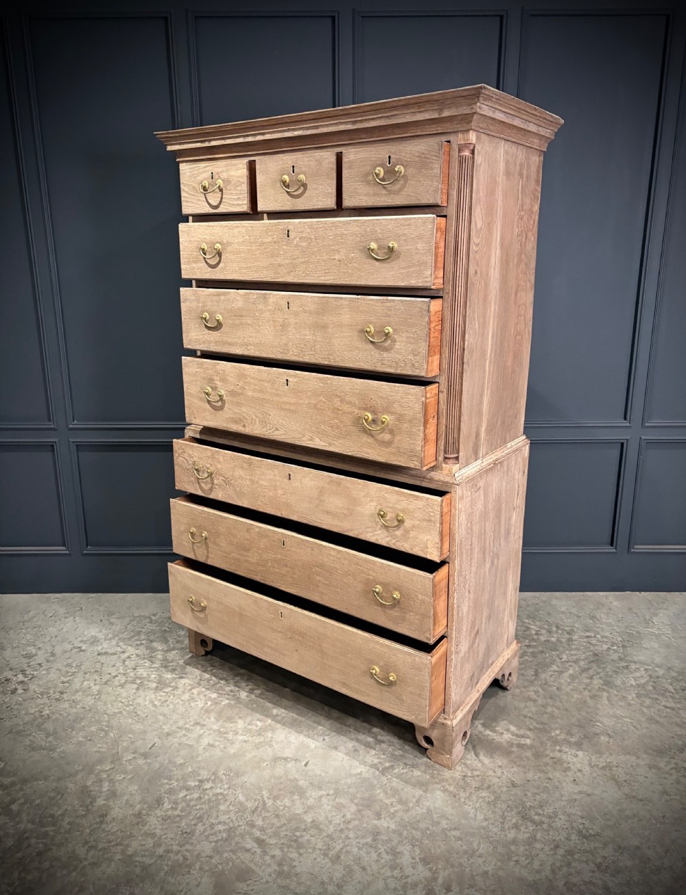 A Georgian bleached oak chest on chest featuring a two-part stacked design with brass drop handles and bracket feet. View IV