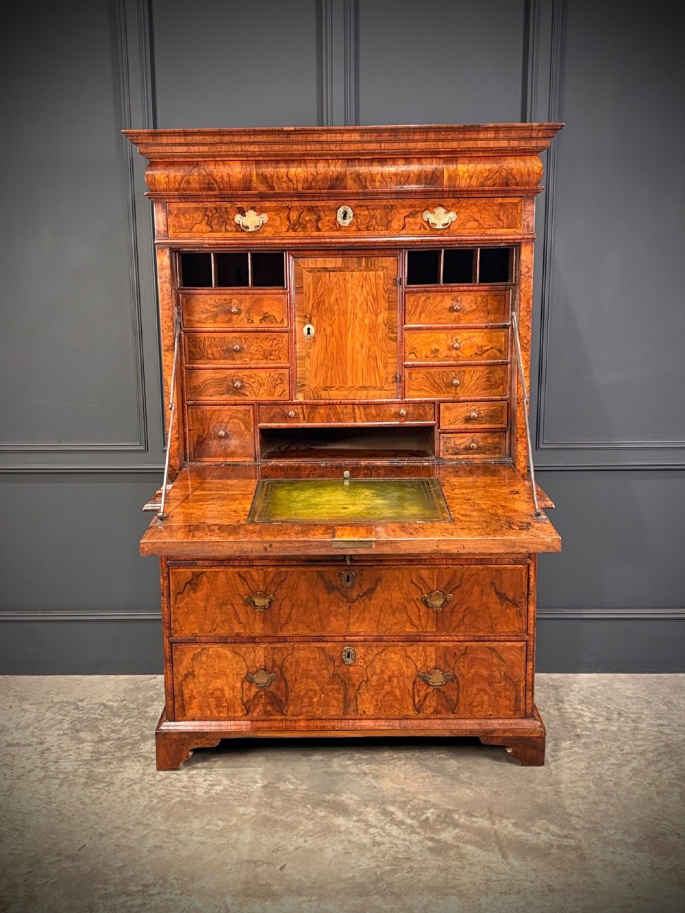 An antique Queen Anne walnut escritoire featuring a drop-front writing surface revealing a fitted interior above a base with drawers. View III