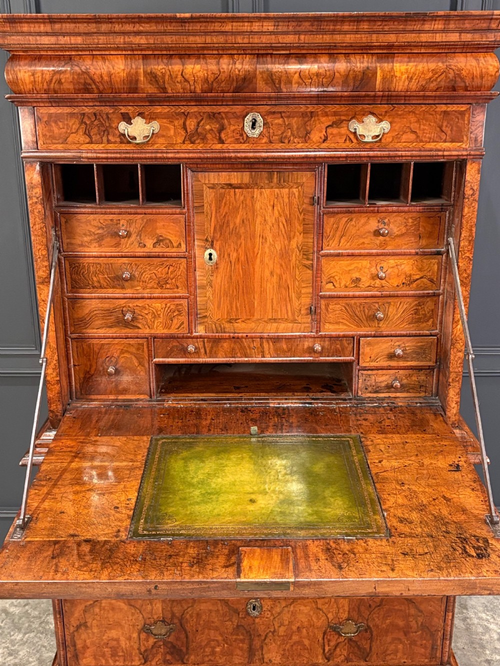 An antique Queen Anne walnut escritoire featuring a drop-front writing surface revealing a fitted interior above a base with drawers. View IV