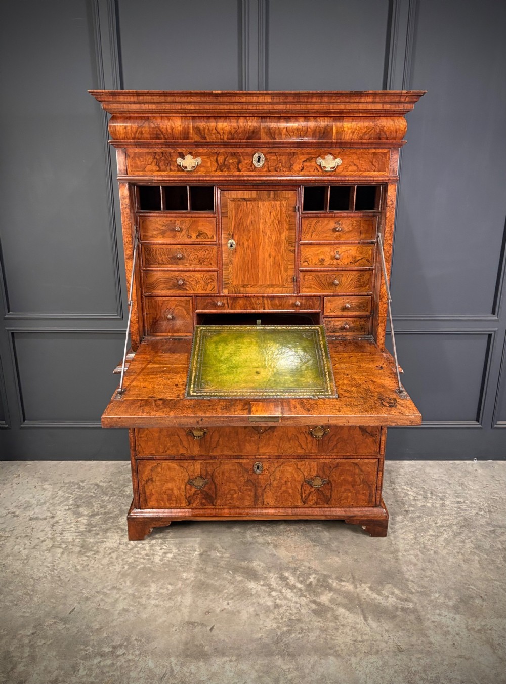 An antique Queen Anne walnut escritoire featuring a drop-front writing surface revealing a fitted interior above a base with drawers. View VII
