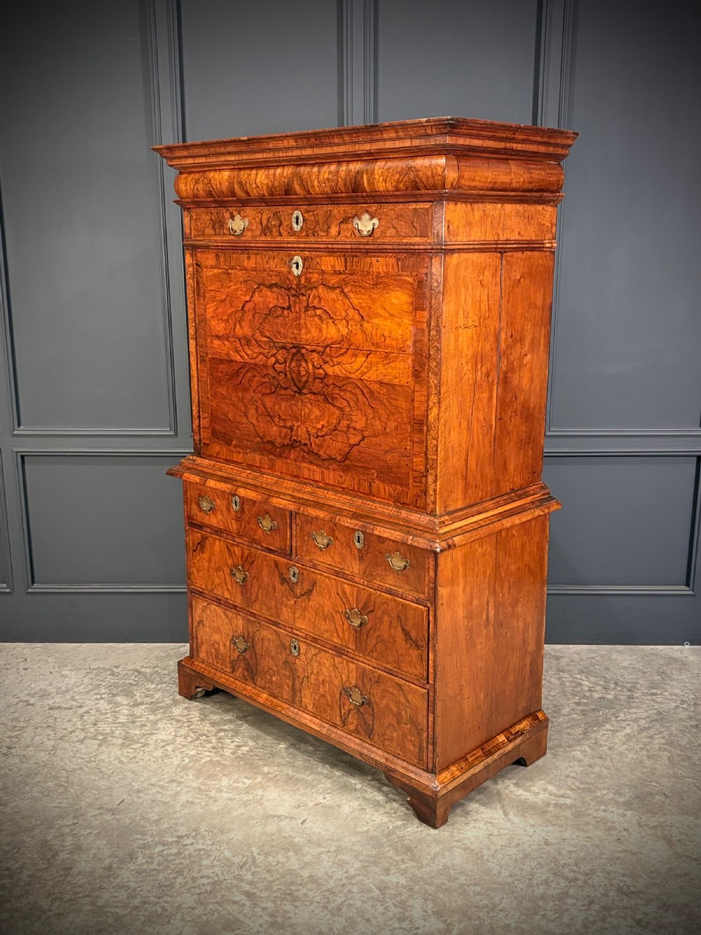 An antique Queen Anne walnut escritoire featuring a drop-front writing surface revealing a fitted interior above a base with drawers. View X
