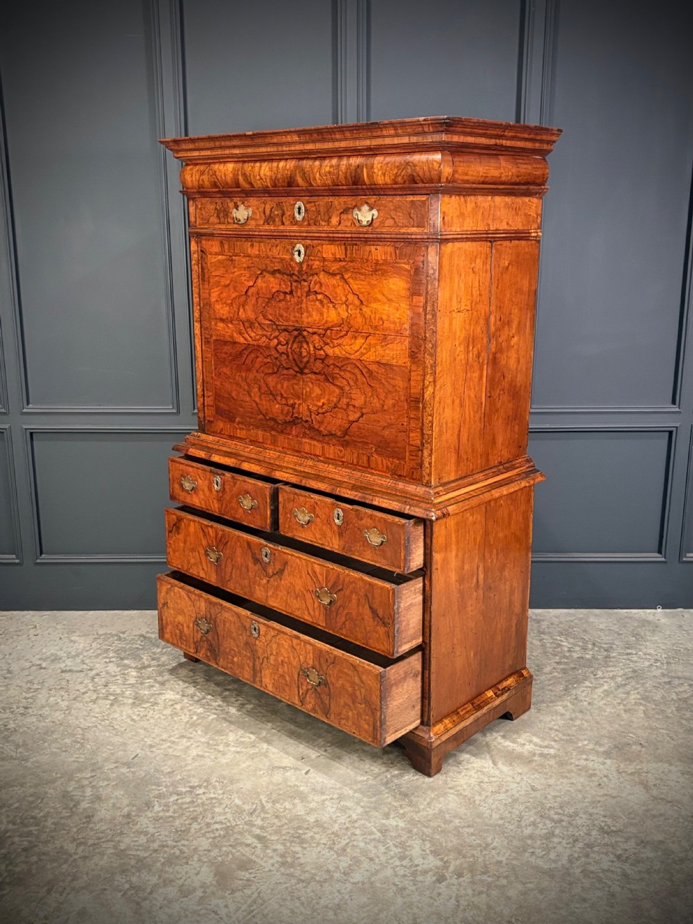 An antique Queen Anne walnut escritoire featuring a drop-front writing surface revealing a fitted interior above a base with drawers. View XI