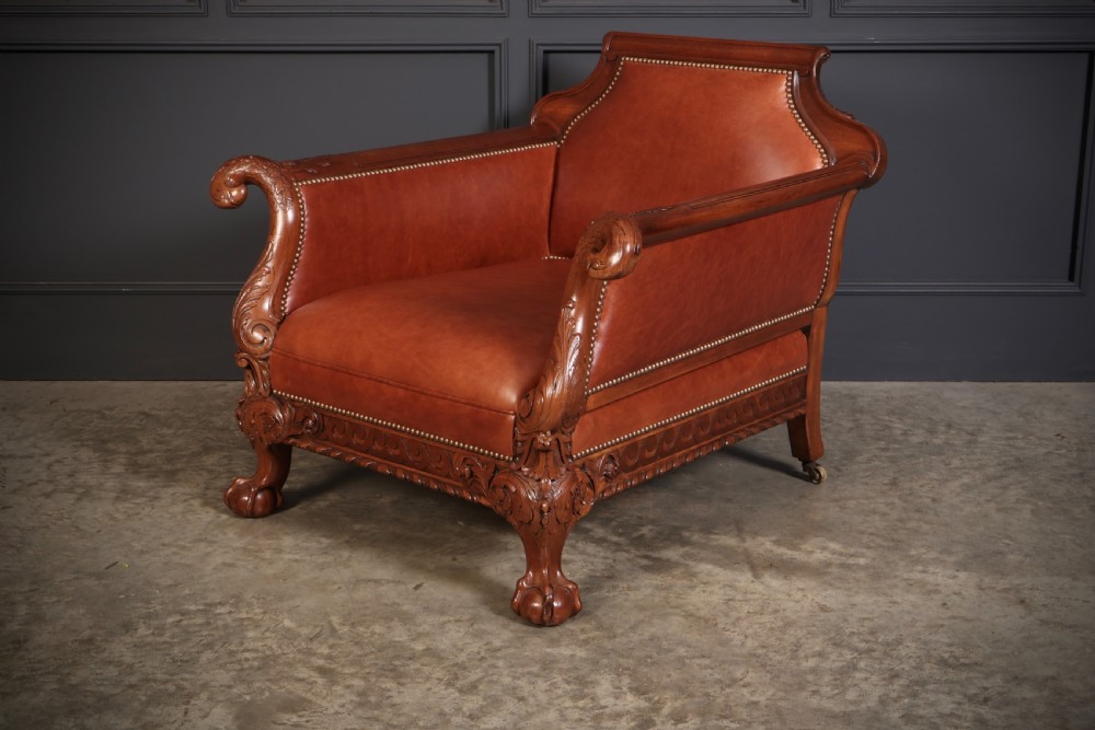 A three-piece lounge suite comprising a three-seater sofa and two matching armchairs upholstered in chestnut brown leather with carved mahogany frames and claw and ball feet. View VIII