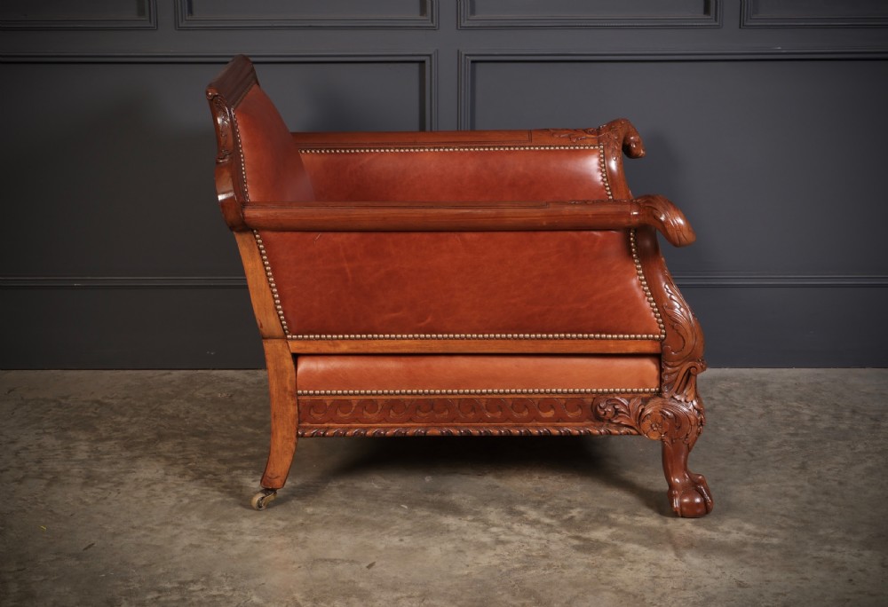 A three-piece lounge suite comprising a three-seater sofa and two matching armchairs upholstered in chestnut brown leather with carved mahogany frames and claw and ball feet. View XI