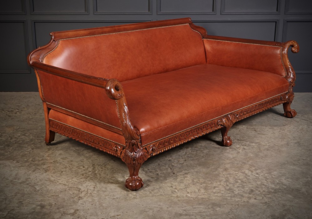 A three-piece lounge suite comprising a three-seater sofa and two matching armchairs upholstered in chestnut brown leather with carved mahogany frames and claw and ball feet. View XIII