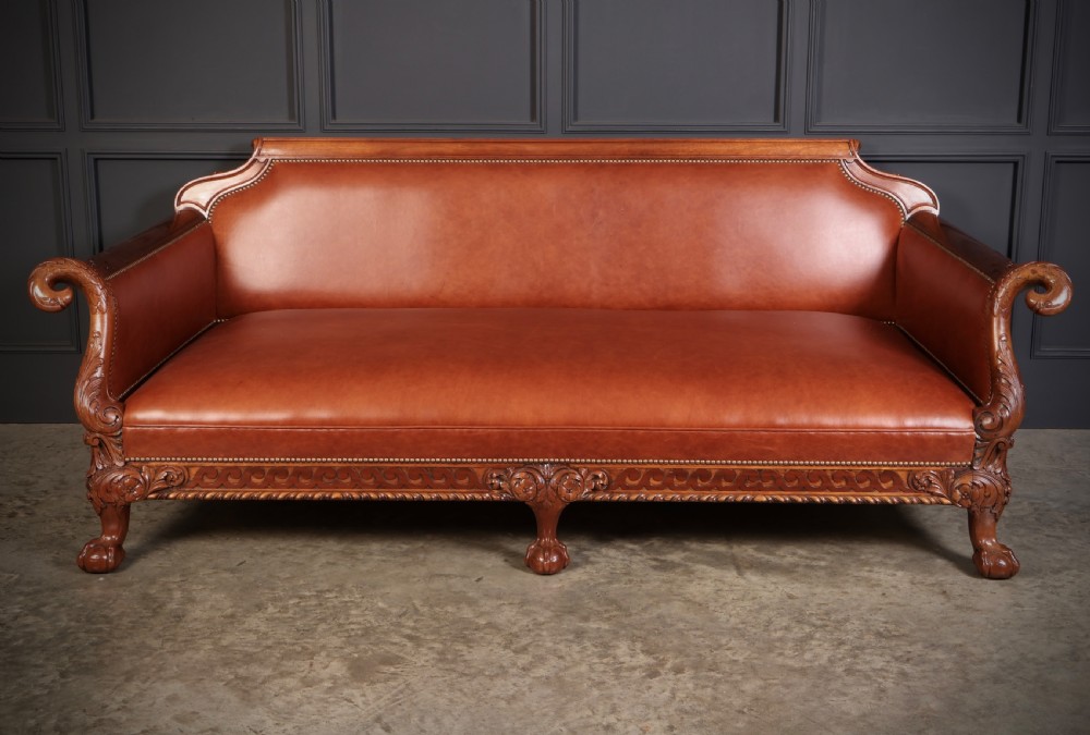 A three-piece lounge suite comprising a three-seater sofa and two matching armchairs upholstered in chestnut brown leather with carved mahogany frames and claw and ball feet. View XIV